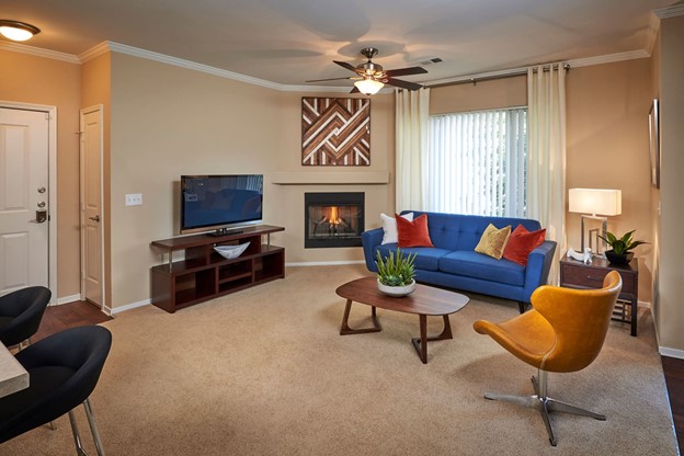 Living room with plush carpeting at Legend Oaks Apartments in Aurora, Colorado